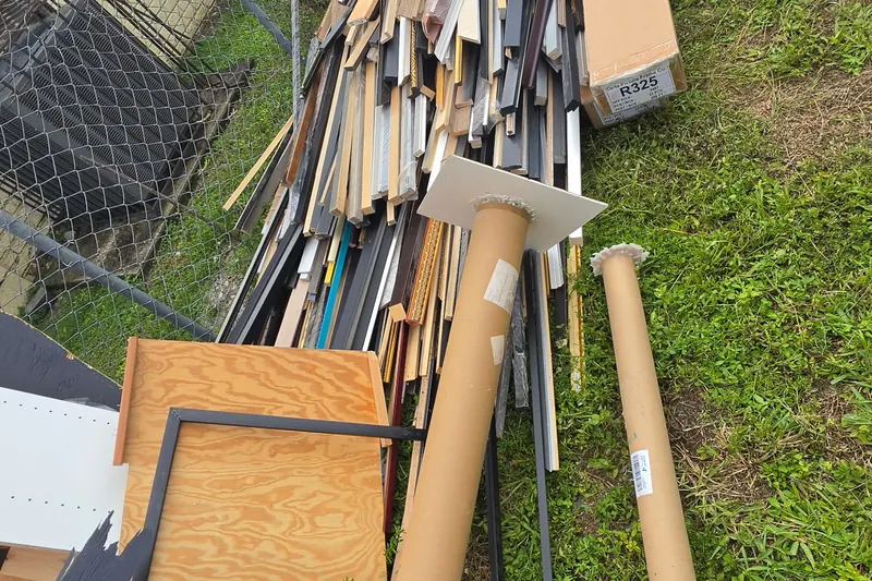 Scrap lumber and trim stacked along a fence